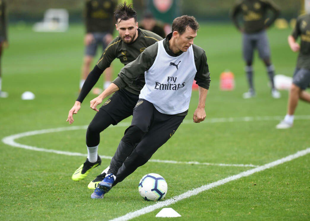 a man in a grey shirt and black pants kicking a soccer ball